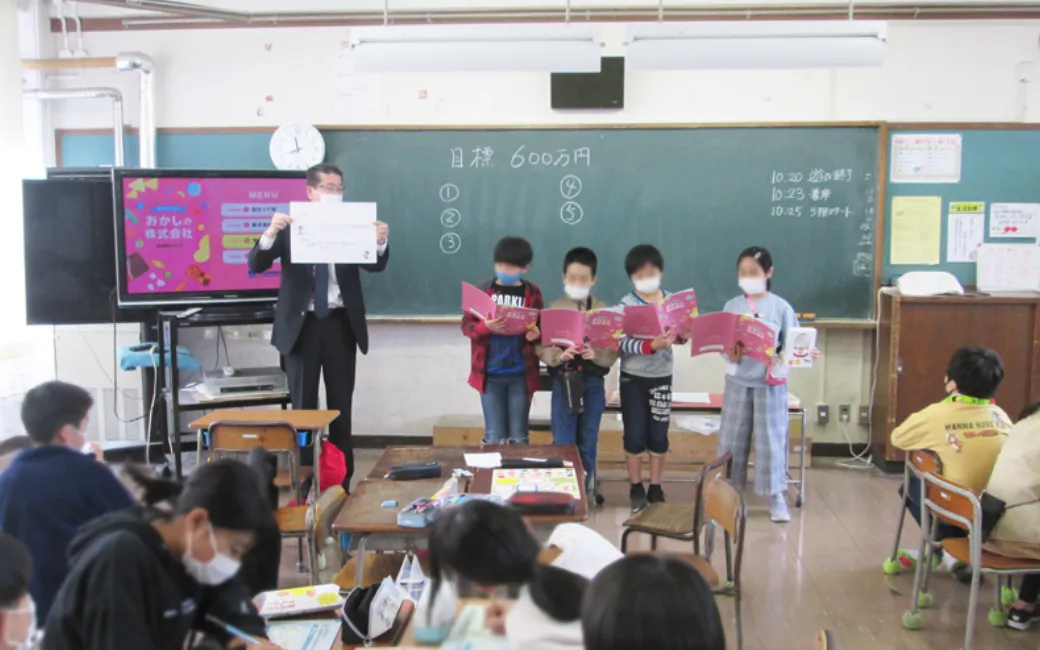 子どもたちへの金融リテラシー教育をしているイメージ